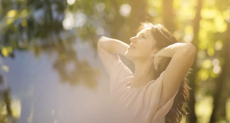 Mujer estirándose al aire libre bajo el sol, energía y bienestar en otoño